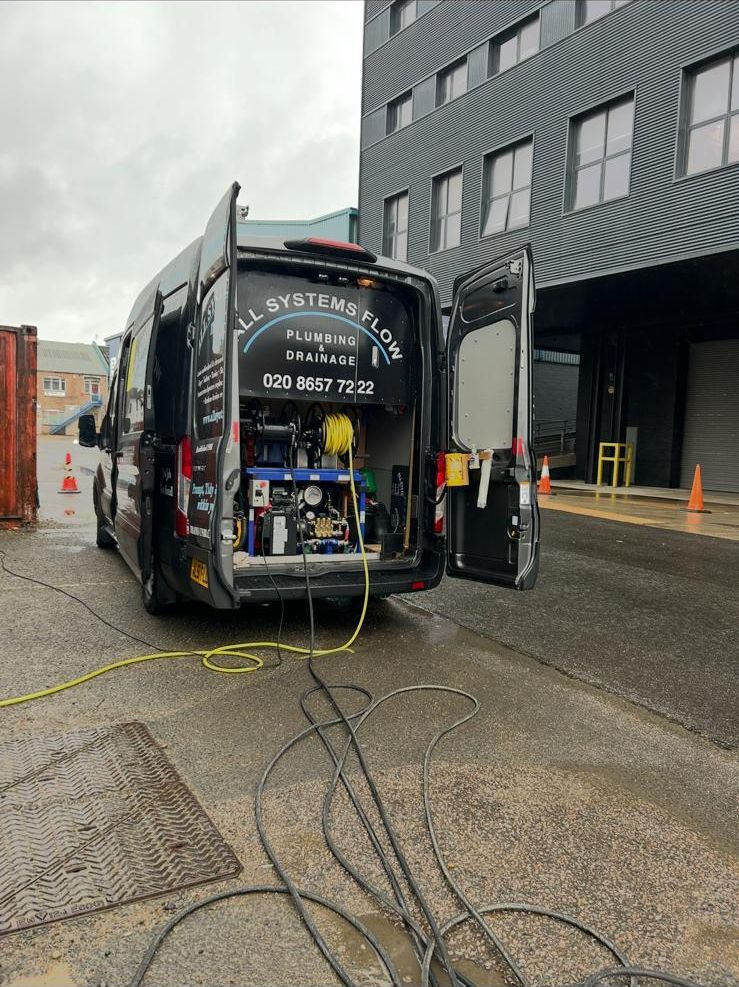 All Systems Flow drainage van with equipment running into a drain — no excavation needed