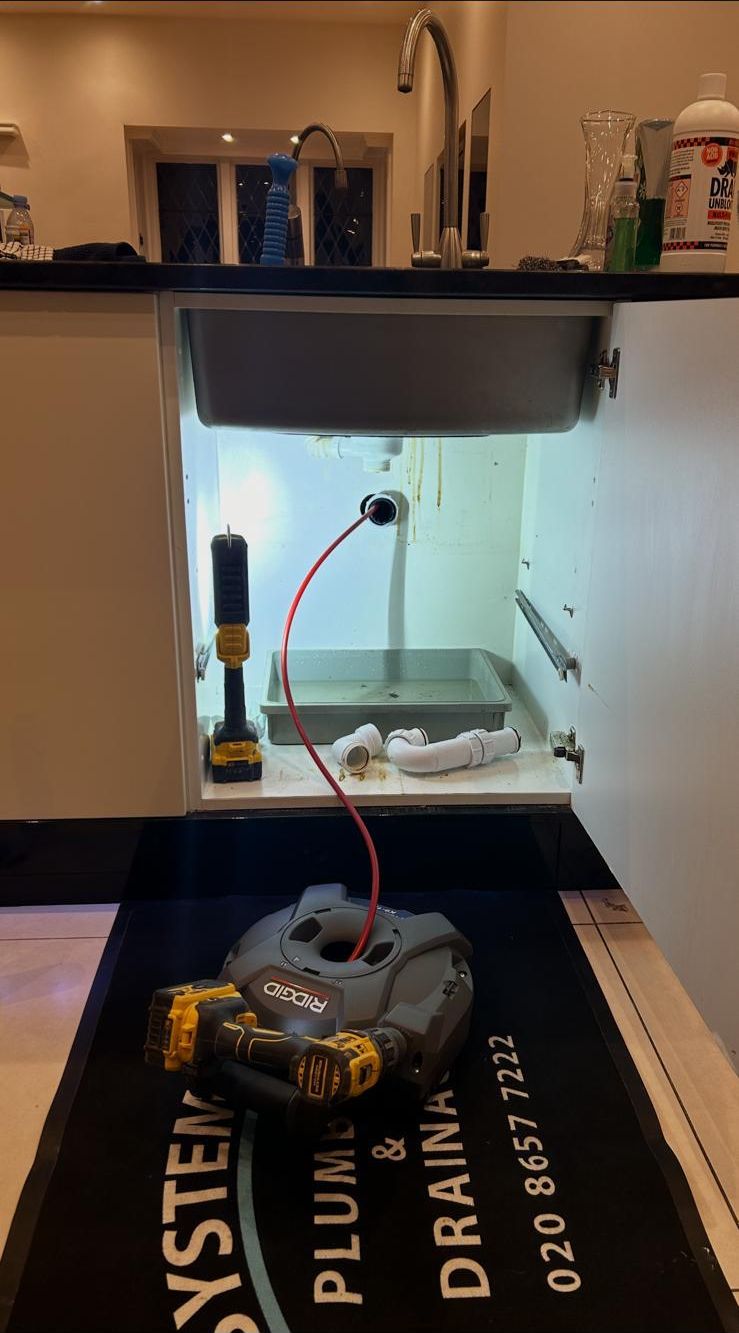 Plumber repairing a kitchen sink in Warlingham